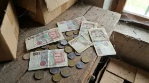 Vecchie banconote e monete italiane in lire su un tavolo impolverato in soffitta